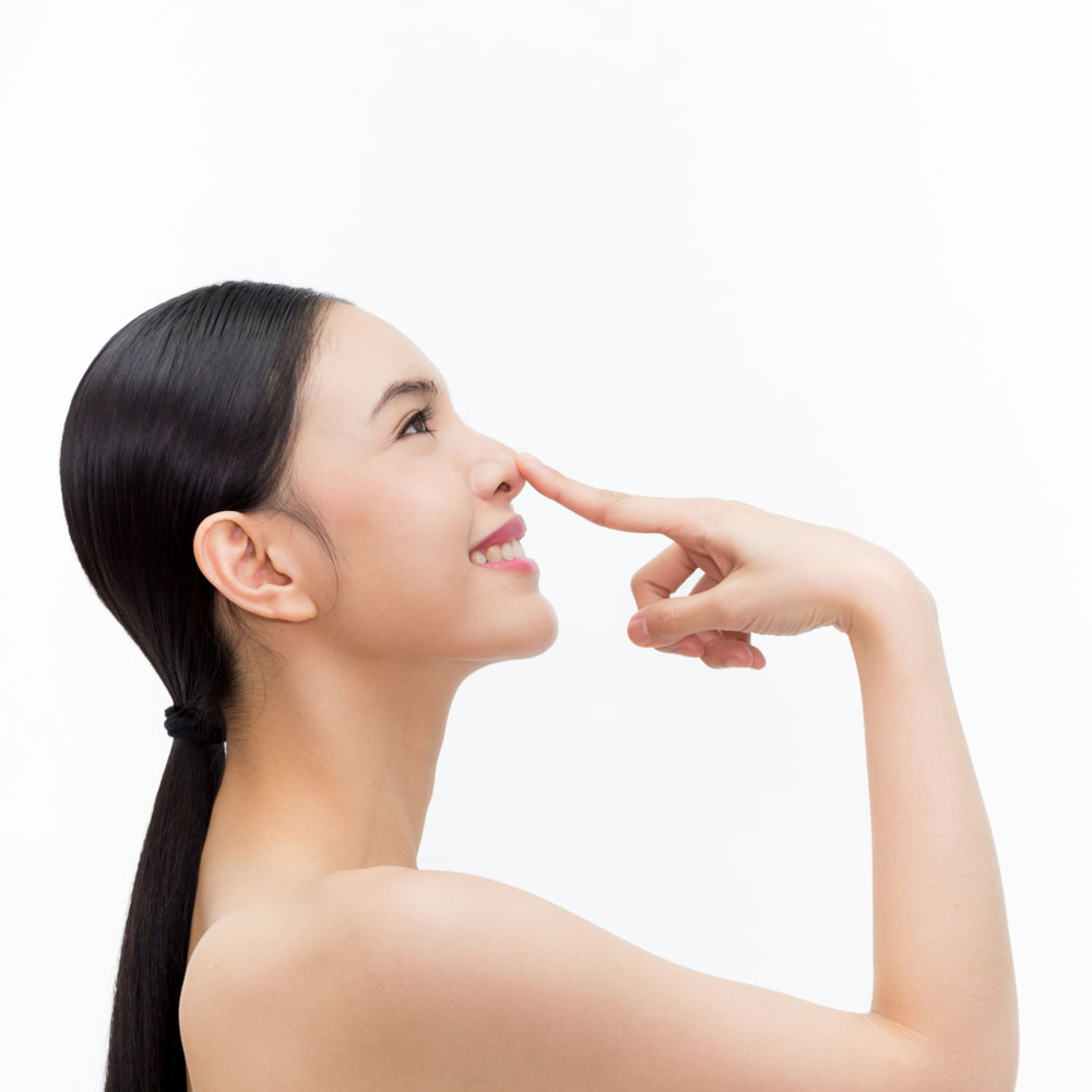 Woman pointing at nose and lookingup