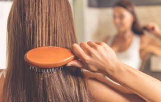 woman brushes thick hair