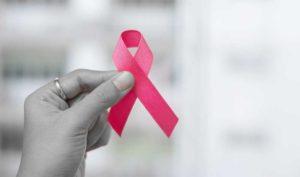 female hand holding breast cancer ribbon