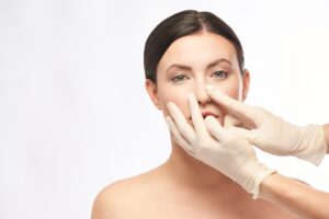 surgeon adjusts woman's nose for nose job