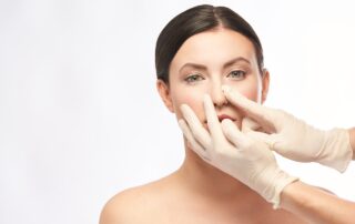 surgeon adjusts woman's nose for nose job