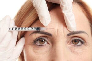 doctor prepares filler for woman's brow