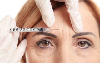 doctor prepares filler for woman's brow