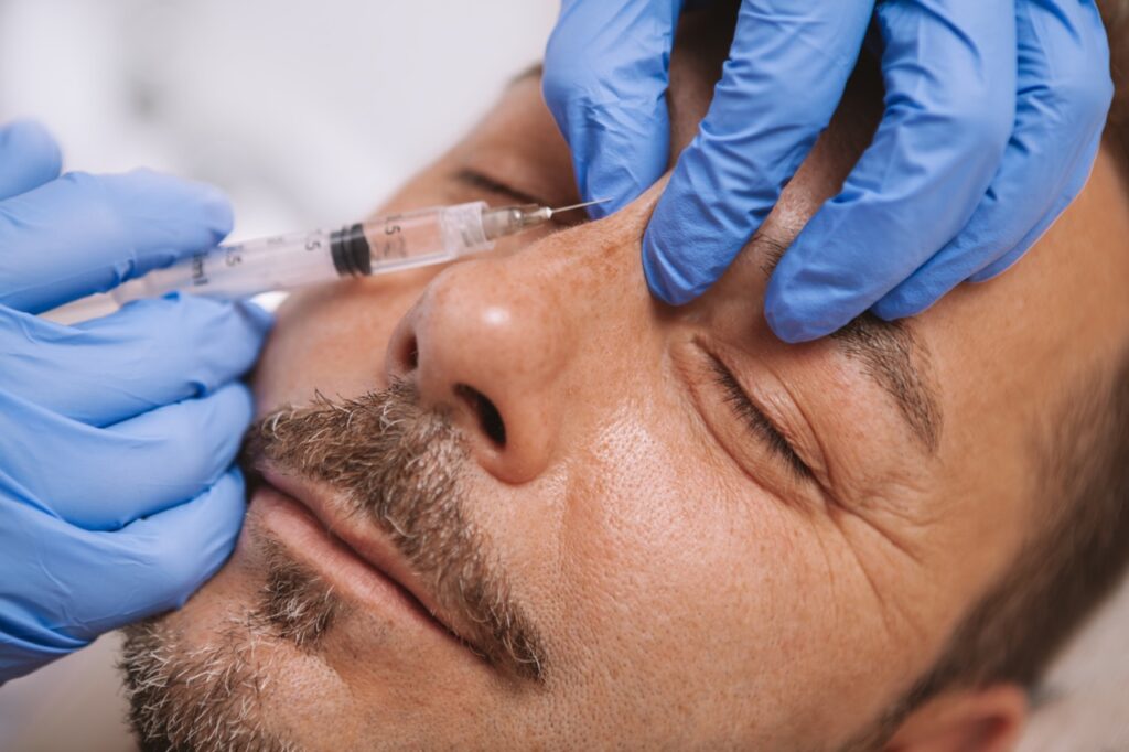 man getting liquid rhinoplasty procedure done by doctor